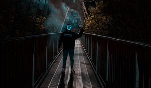 Превью обои человек, аноним, маска, неон, дым, мост