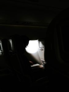 Превью обои человек, иллюминатор, самолет, темный, лучи