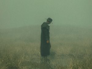 Превью обои человек, плащ, шляпа, поле, туман, темный, арт