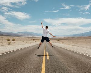 Превью обои человек, прыжок, левитация, дорога, пустыня