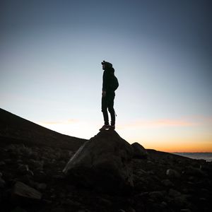 Превью обои человек, силуэт, камень, сумерки, темный
