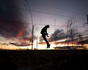 Превью обои человек, силуэт, прыжок, закат, трава