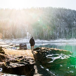 Превью обои человек, скалы, горы, озеро, солнечный свет, природа