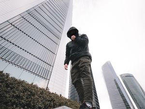 Превью обои человек, стиль, капюшон, вид снизу, здания