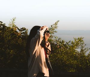 Превью обои девушка, фотограф, фотоаппарат, кусты