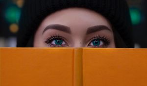 Превью обои девушка, книга, взгляд, глаза, лицо