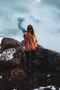 Превью обои девушка, маска, дым, дымовая шашка, камни