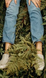 Превью обои девушка, ноги, джинсы, руки, трава