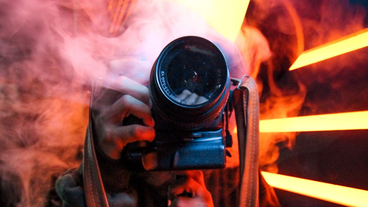 Обои фотоаппарат, дым, фотограф, объектив, неон, свет