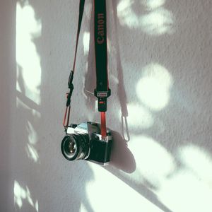 Превью обои фотоаппарат, камера, ремень, стена, тень