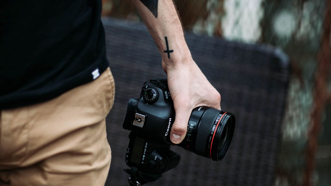 Обои фотоаппарат, рука, татуировки, фотограф