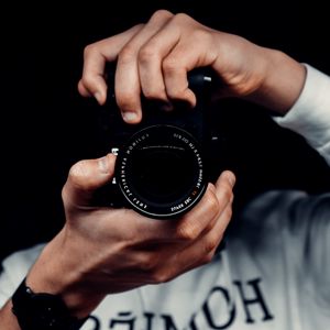 Превью обои фотограф, фотоаппарат, объектив, техника, фокус