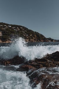 Превью обои город, холм, море, брызги, скалы