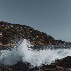 Превью обои город, холм, море, брызги, скалы