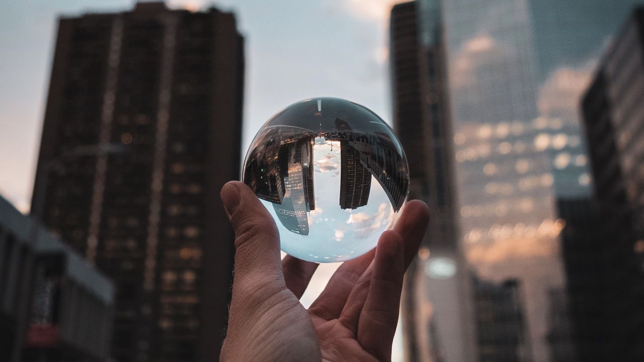 Обои хрустальный шар, шар, рука, отражение, город, здания