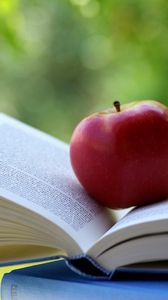 Превью обои яблоко, книга, блики, размытость