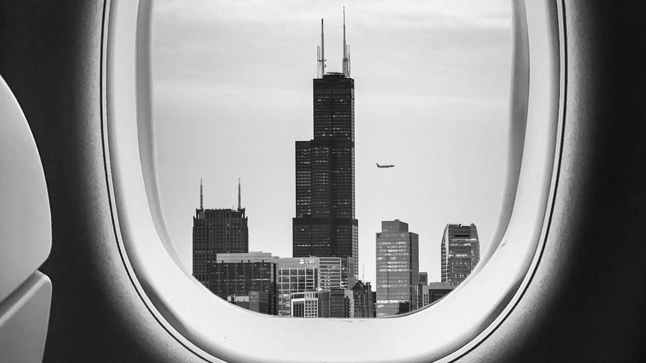 Обои иллюминатор, чб, окно самолета, здания, полет