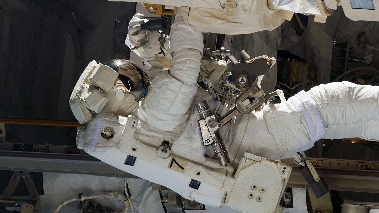 Обои космонавт, скафандр, корабль, корпус, ремонт, оборудование