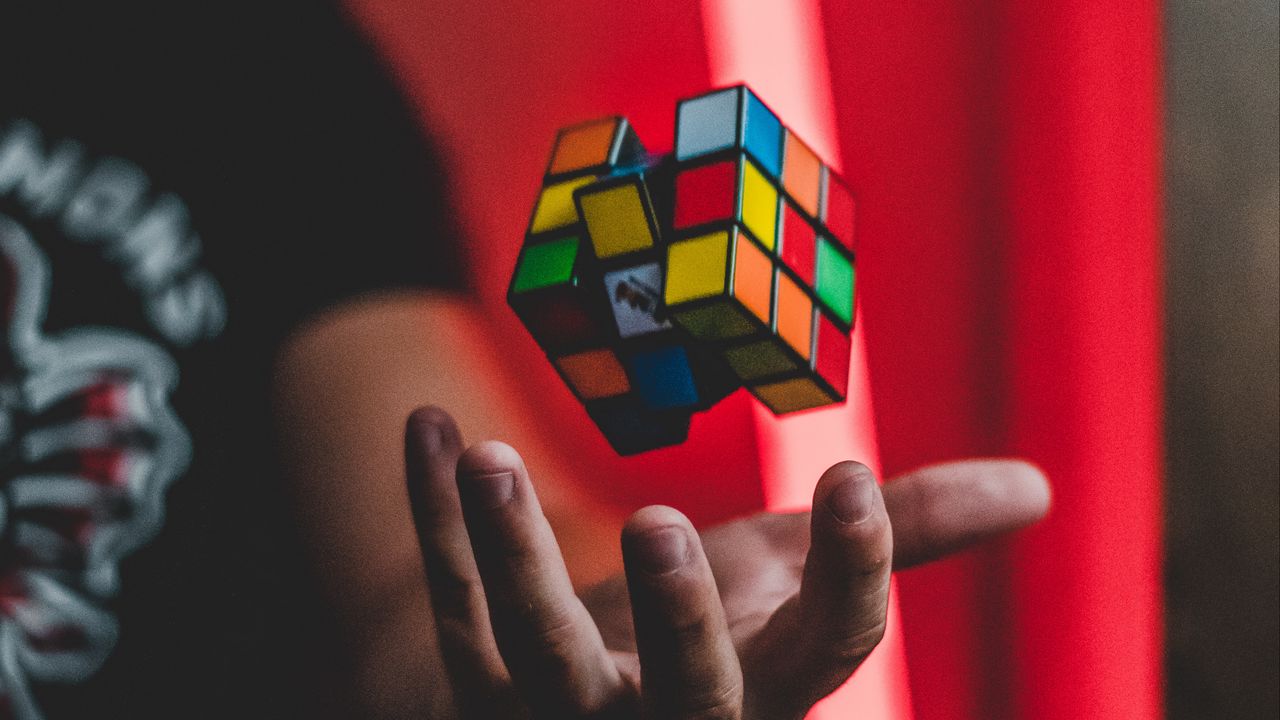 Обои кубик рубика, рука, левитация, разноцветный