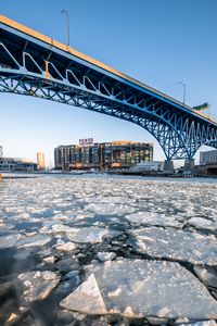 Превью обои лед, вода, трещины, мост, здание, зима