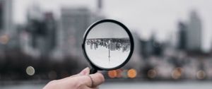 Превью обои лупа, рука, город, размытость, фокус