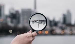 Превью обои лупа, рука, город, размытость, фокус
