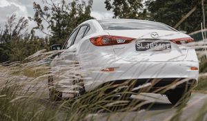 Превью обои mazda 3, mazda, автомобиль, белый, вид сзади, трава, деревья