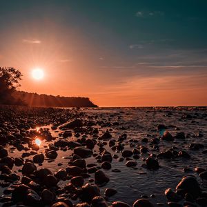 Превью обои море, закат, камни, берег, свет