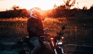 Превью обои мотоцикл, мотоциклист, шлем, закат, свет