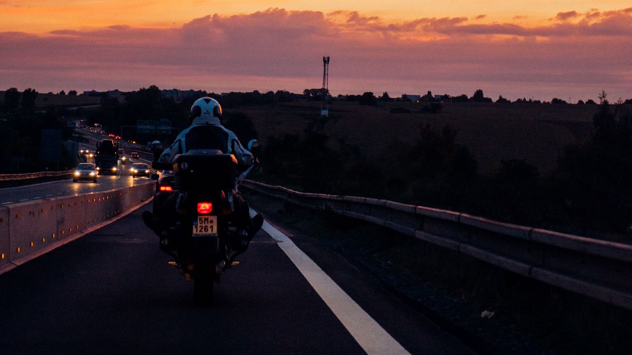Обои мотоциклист, закат, небо, облака, дорога, разметка