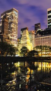 Превью обои нью-йорк, город, центр нью йорка, большой город, дома, здания, деревья, тучи, пасмурно, манхэттен, озеро, подсветка, огни, ночной город, красиво, красивое небо, водоём, отражение