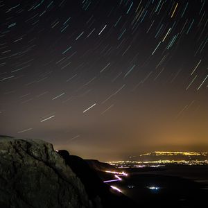 Превью обои ночной город, звездное небо, длинная выдержка, скалы