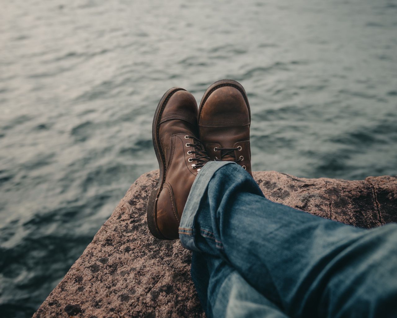 Foot rock. Ноги в ботинки на фоне озера Пристань. Мужская обувь на море. Ботинки и из них вода на море. Сапог море похоже.