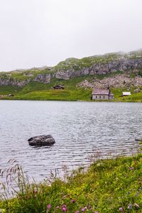 Превью обои пейзаж, озеро, дома, камень, берег, трава