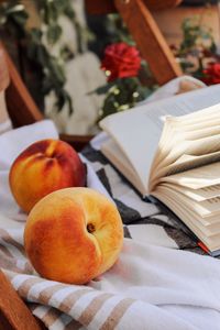Превью обои персик, фрукт, книга, страницы, ткань