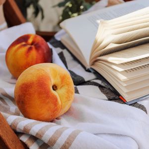 Превью обои персик, фрукт, книга, страницы, ткань
