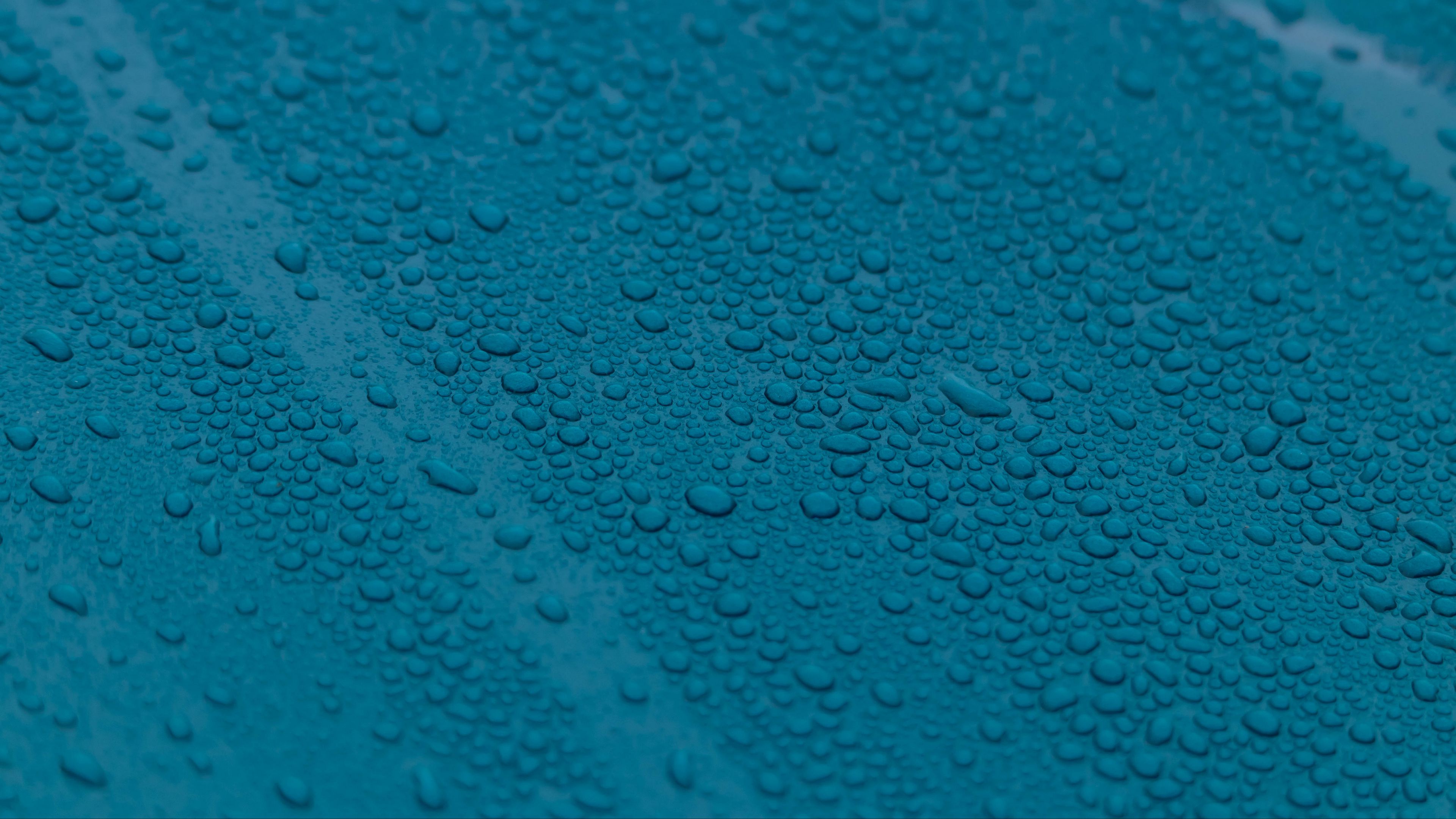 Капли голубая вода. Синий фон вода. Капли на поверхности. Обои на рабочий стол капли воды. Синяя поверхность воды.