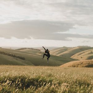 Превью обои прыжок, левитация, силуэт, поле, холмы