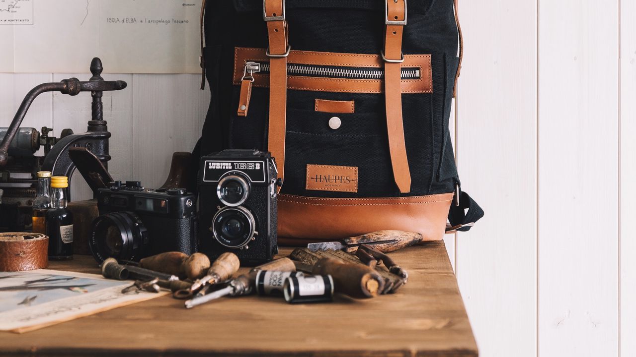 Обои рюкзак, фотоаппараты, инструменты, карты, шляпа
