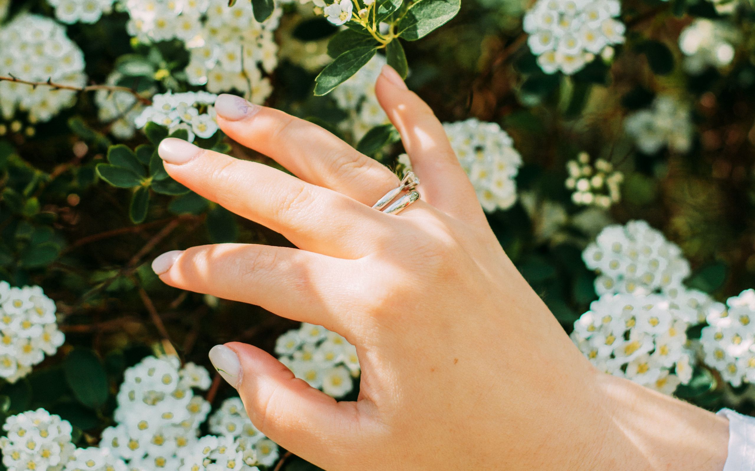 Рука с кольцом на фоне цветов