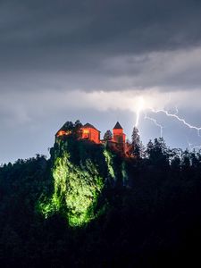 Превью обои скала, дом, свет, молния, сумерки
