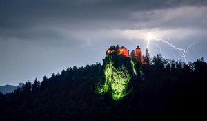 Превью обои скала, дом, свет, молния, сумерки