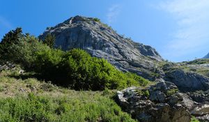 Превью обои скала, камни, кусты, природа, небо, вид снизу, пейзаж