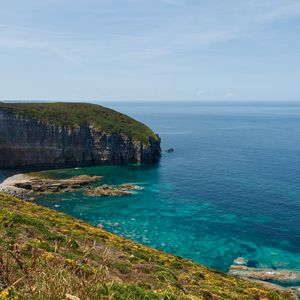 Превью обои скала, склон, море, трава, небо