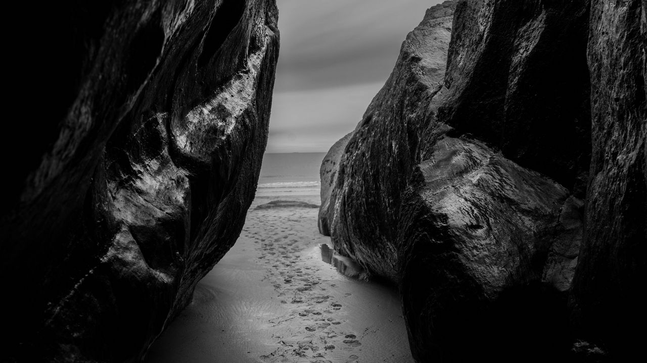 Обои скалы, песок, следы, море, черно-белый