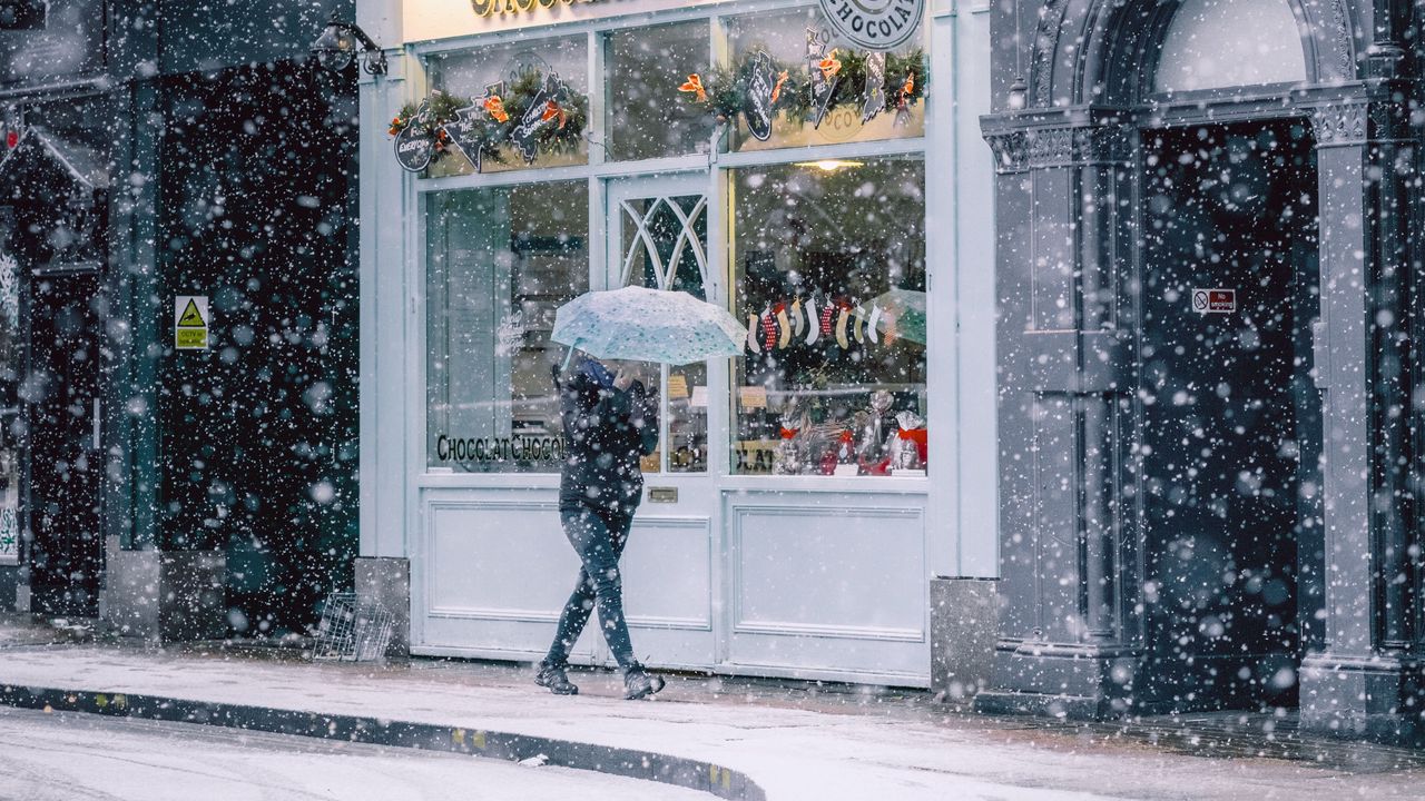Обои снегопад, человек, здания, улица, прогулка