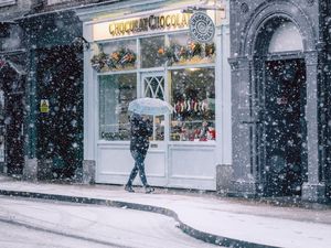 Превью обои снегопад, человек, здания, улица, прогулка