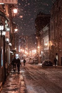 Превью обои снегопад, люди, улица, ночь, вечер, город, зима