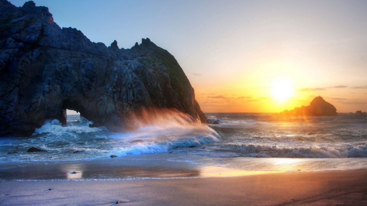 Обои солнце, свет, закат, берег, пляж, арка, скала, брызги, волны, пена, песок, безмятежность