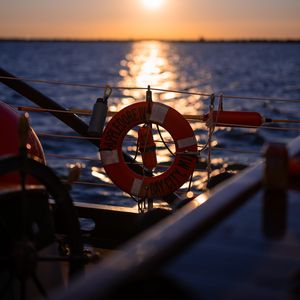 Превью обои спасательный круг, море, закат, размытие